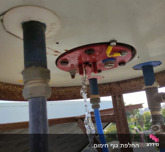 מים זורמים מצינור בדוד שמש עם חיבורים.